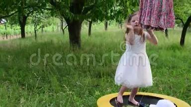 一个可爱的<strong>女孩</strong>在自然花园里<strong>跳舞</strong>。 小<strong>女孩</strong>在一个小蹦床上<strong>跳舞</strong>和跳跃。 小<strong>女孩</strong>穿白色衣服